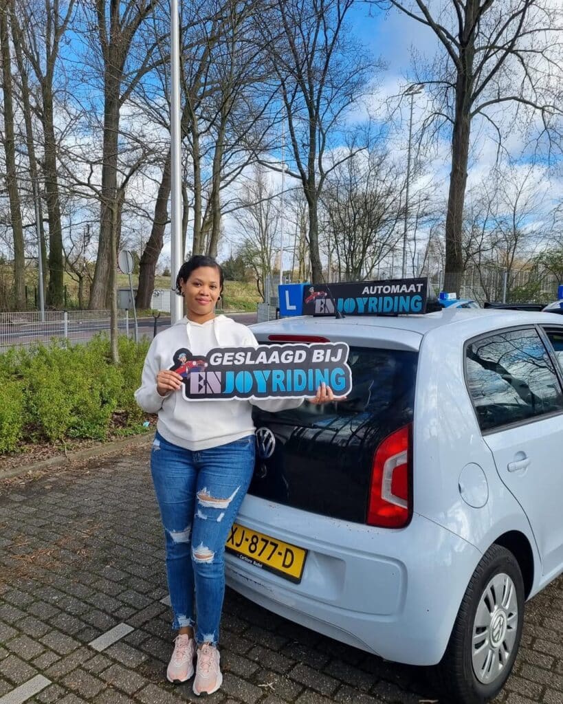 Geslaagde cursiste toont trots haar rijbewijs certificaat bij Rijschool EnjoyRiding auto Geslaagde cursiste toont trots haar rijbewijs certificaat bij Rijschool EnjoyRiding auto