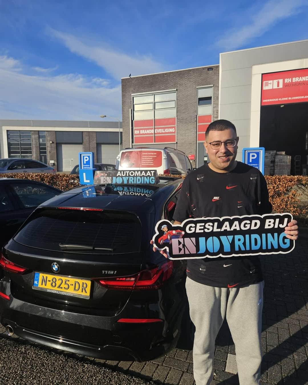 Geslaagde rijschoolstudent van Rijschool EnjoyRiding toont certificaat bij BMW rijlesauto