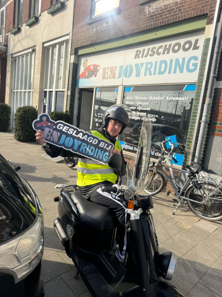 Geslaagde student toont certificaat voor Rijschool EnjoyRiding na het behalen van scooterrijbewijs Geslaagde student toont certificaat voor Rijschool EnjoyRiding na het behalen van scooterrijbewijs